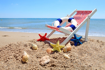 Fototapeta na wymiar Beach chair near the ocean with shells