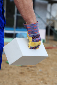 Bauarbeiter mit Ziegelstein in der Hand