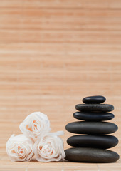 Obraz na płótnie Canvas Roses and a black pebbles stack