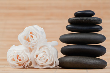 Fototapeta na wymiar Close up roses and a black pebbles stack