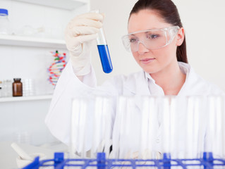 Beautiful red-haired woman holding a test tube
