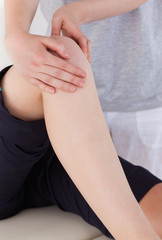 Portrait of a masseuse massing the knee of an athletic woman