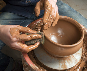 hands of a potter, creating an earthen jar on the circle