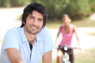man and woman riding bike outdoors