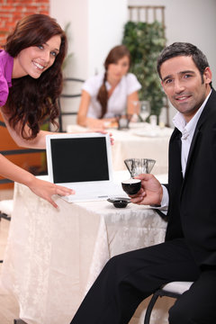 Couple looking at a blank computer screen in a restaurant
