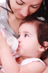 Mother and baby drinking milk from bottle in a white background.