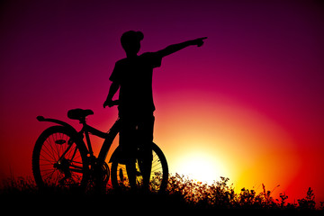 The boy on a bicycle against a decline