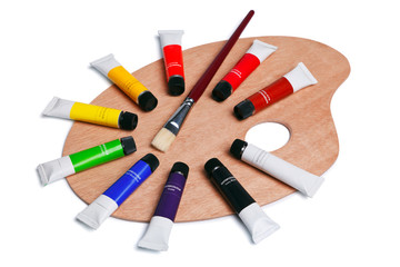 Wooden palette with tubes of paint isolated on white