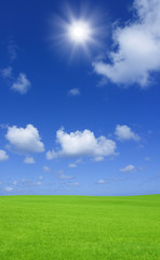 Fototapeta na wymiar Słońce i chmury i zielone łąki