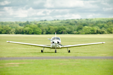 Fototapeta na wymiar light aircraft on a grass airstrip with blurred background