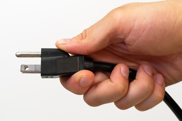 North American electrical cord held in a man's hand