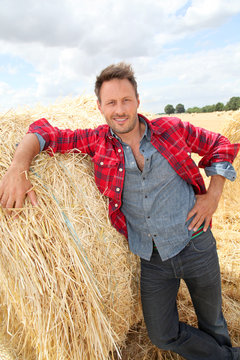 Handsome Farmer Standing By Hay Bale