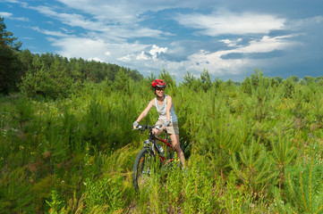 Naklejka na ściany i meble Woman riding bicycle in forest