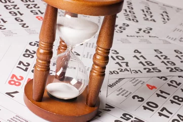 Fotobehang hourglass on calendar sheets © Vladimir Voronin