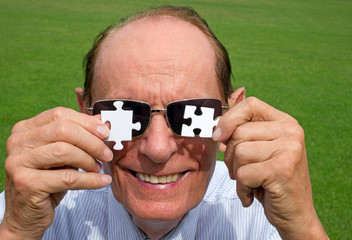 Fototapeta premium Lustiger Rentner oder Senior mit Puzzle