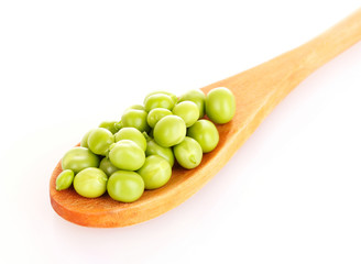 Green peas in wooden spoon isolated on white