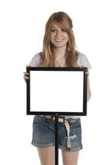 Young girl holding standing behind sign