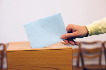 Frau bei Wahl mit Stimmzettel und Wahlurne