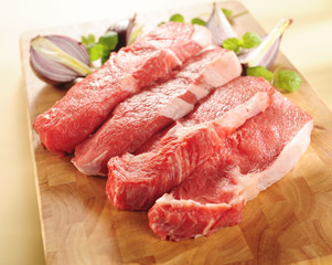 Raw beef steaks. Arrangement on a cutting board.