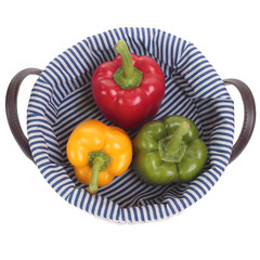 Colored pepper on basket. Isolated on a white background