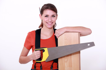 Woman sawing a wooden floor board