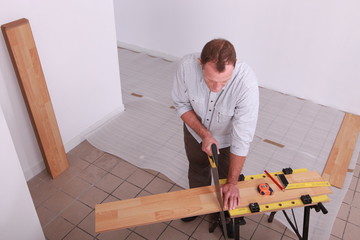 Man laying a wooden floor