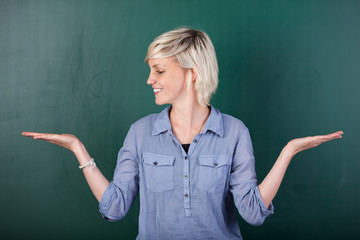 frau vor der tafel hält etwas in der hand