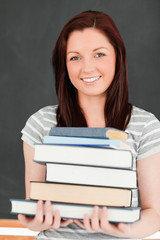 Portrait of a smiling redhead holding books