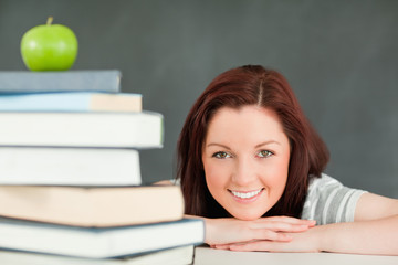 Young student with an apple and books in the foreground