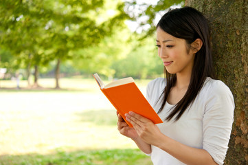 Fototapeta premium beautiful asian woman reading a book in the park