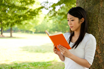 Fototapeta premium beautiful asian woman reading a book in the park