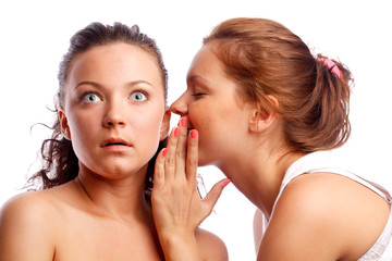 Young woman whispering something to her frind.