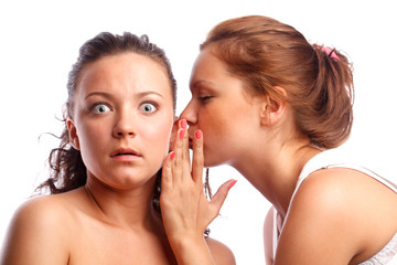 Young woman whispering something to her frind.