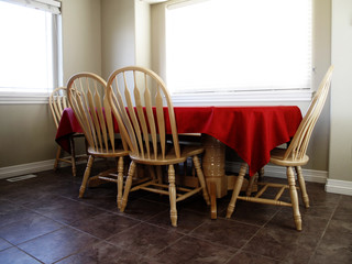Clean kitchen table with tablecloth near bright windows