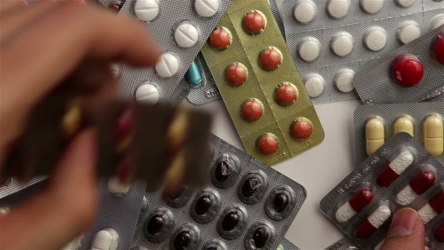 Hand grabbing pill packages