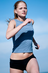 Sport teenage girl running over blue sky