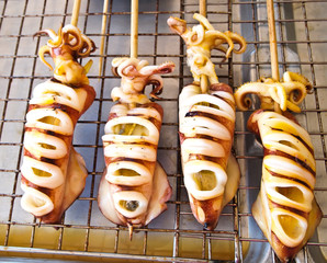 Skewered squid on wooden sticks grilled tentacles