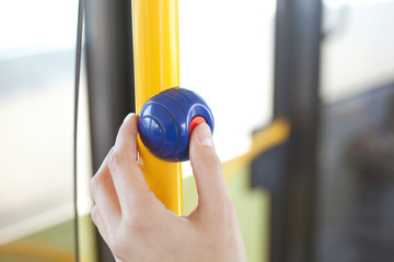 finger drückt stop-drücker an haltestange im bus