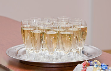 Many glasses full of champagne on the tray