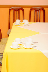 empty coffee cups with saucers on table setting