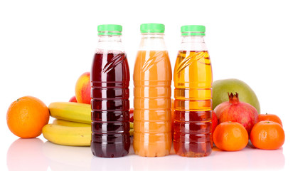 bottles of juice  with ripe fruits on white background