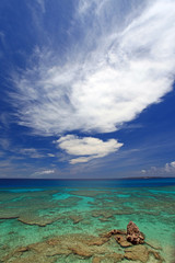 コマカ島の澄んだサンゴ礁の海と大きな白い雲
