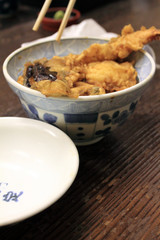 Sushi rice bowl filled with raw seafood..