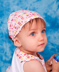 portrait d'une fillette aux yeux bleus sur fond bleu