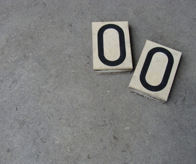 2 plastic 0 zero number on gray stone surface