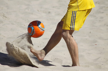 Man playing soccer on a beach
