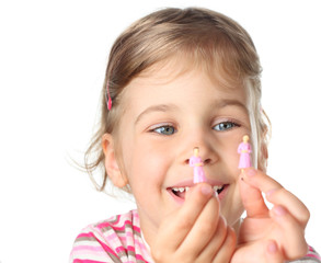 little girl holding small toy figures of woman and smiling