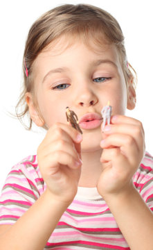 little girl holding small toy figures of people isolated