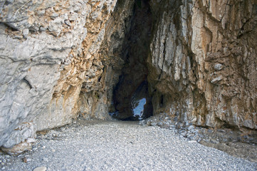 Rock with grotto on the beach, Cilento, Italy