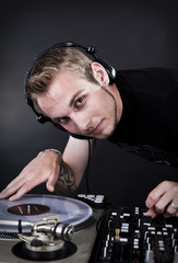 discjockey mit kopfhörern regelt mischpult